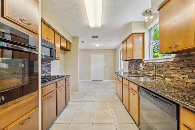 a kitchen with stainless steel appliances granite countertop a sink and a stove