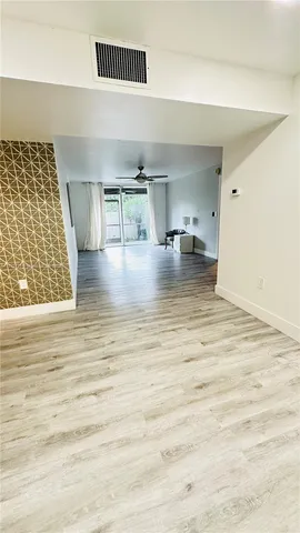 a view of empty room with kitchen and window