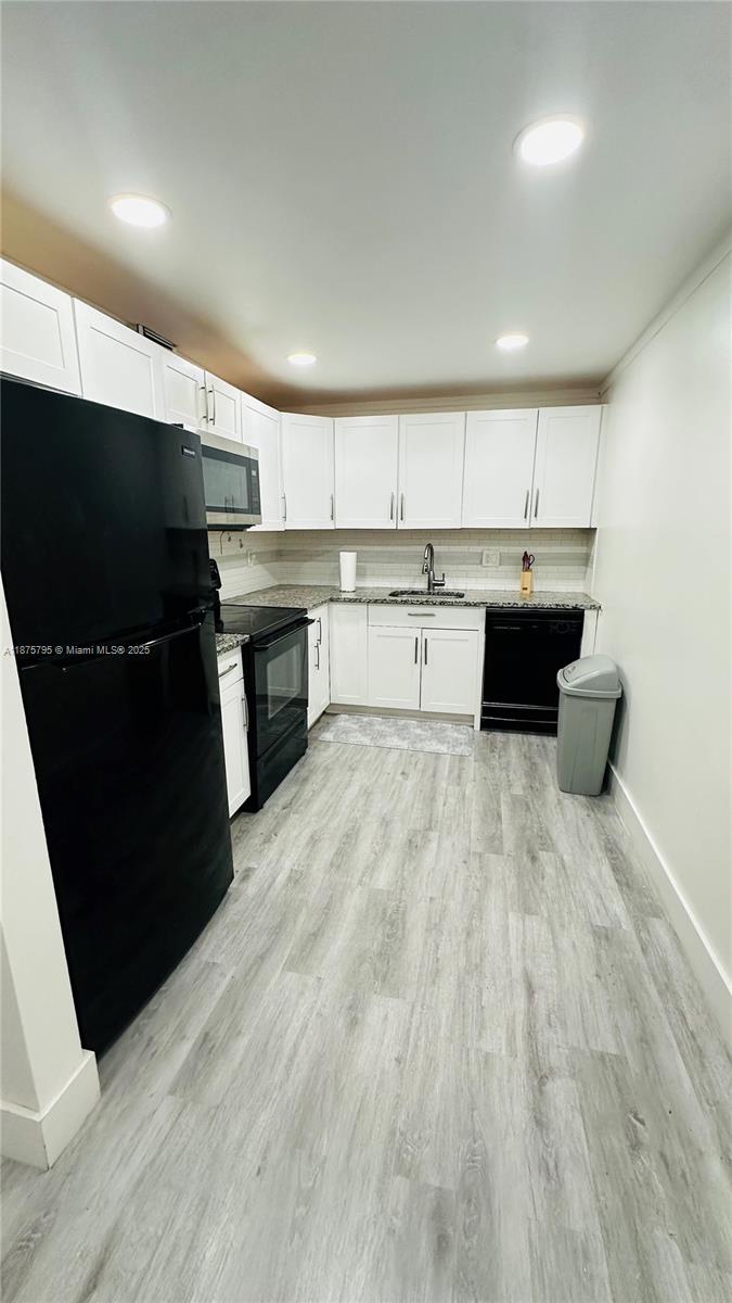 7100 Northwest 17th Street, Unit 111 Plantation, FL 33313 - Photo 3 of 18 a kitchen with stainless steel appliances kitchen island granite countertop a refrigerator a sink and a stove top oven