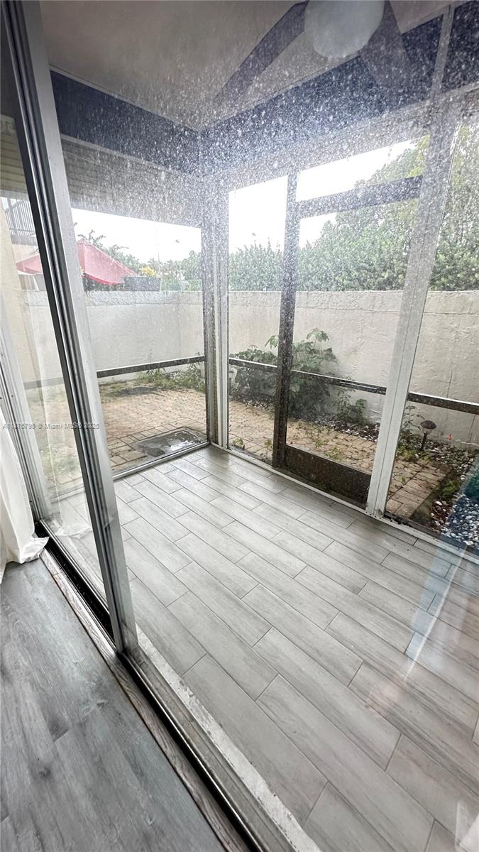 7100 Northwest 17th Street, Unit 111 Plantation, FL 33313 - Photo 5 of 18 a view of an empty room with wooden floor and a window