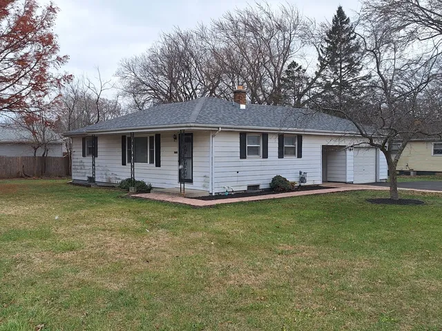 a front view of house with yard and trees