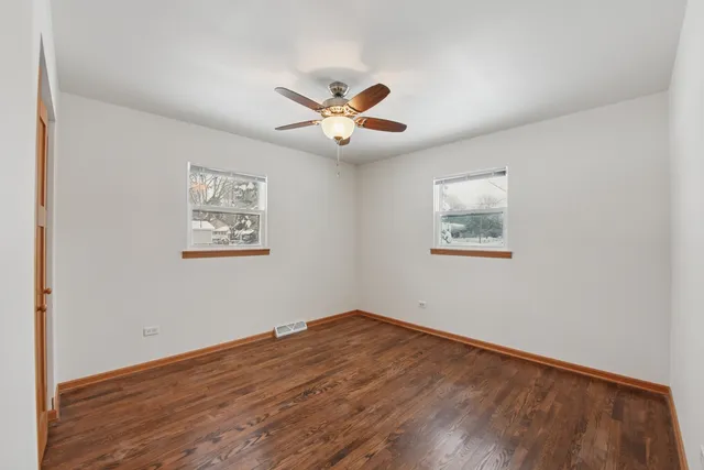 a view of a big room with wooden floor and a ceiling fan