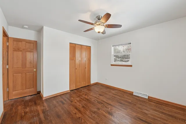 a view of a big room with wooden floor and windows