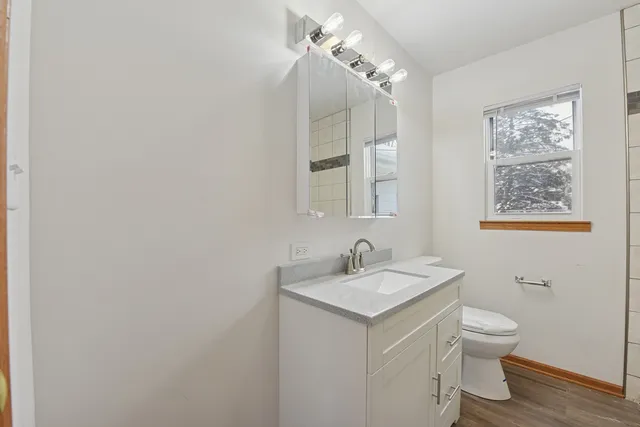 a bathroom with a toilet a sink and mirror