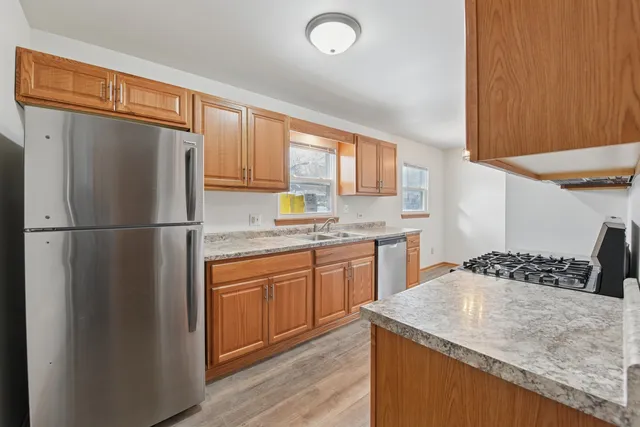 a kitchen with stainless steel appliances granite countertop a sink stove and refrigerator