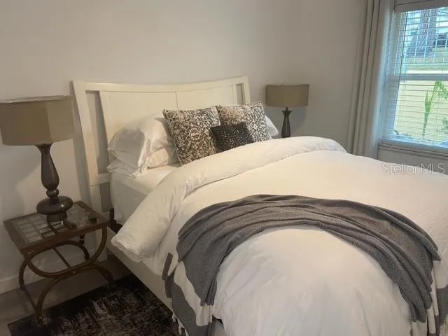 a spacious bedroom with a bed and a window