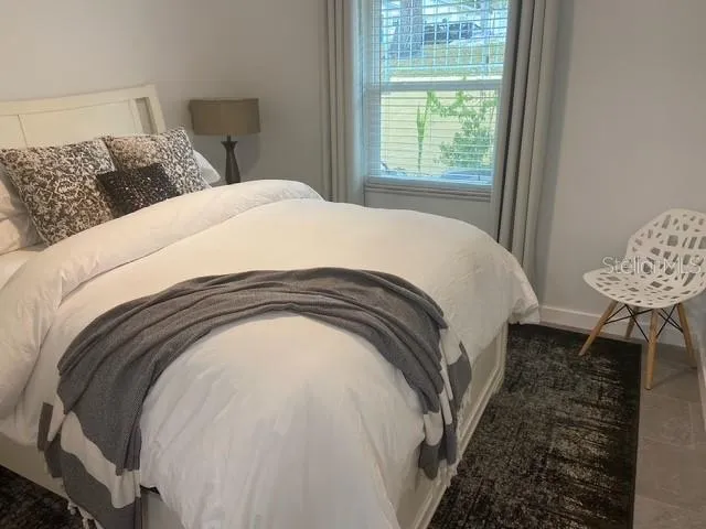 a spacious bedroom with a bed and a window