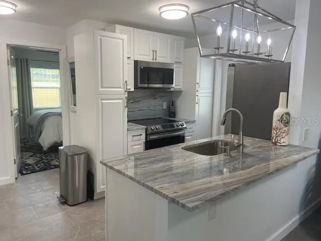 a kitchen with sink a microwave and refrigerator