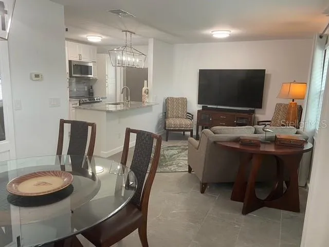a dining room with furniture and a flat screen tv