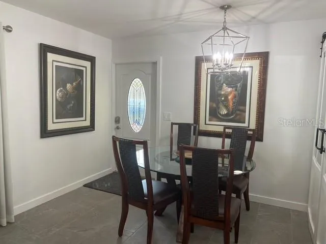 a view of a dining room with furniture a chandelier and wooden floor