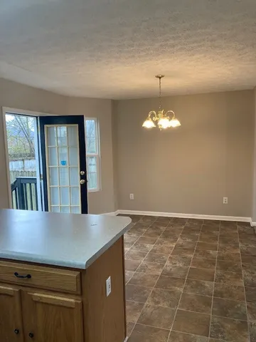 a view of a kitchen with a sink and chandelier