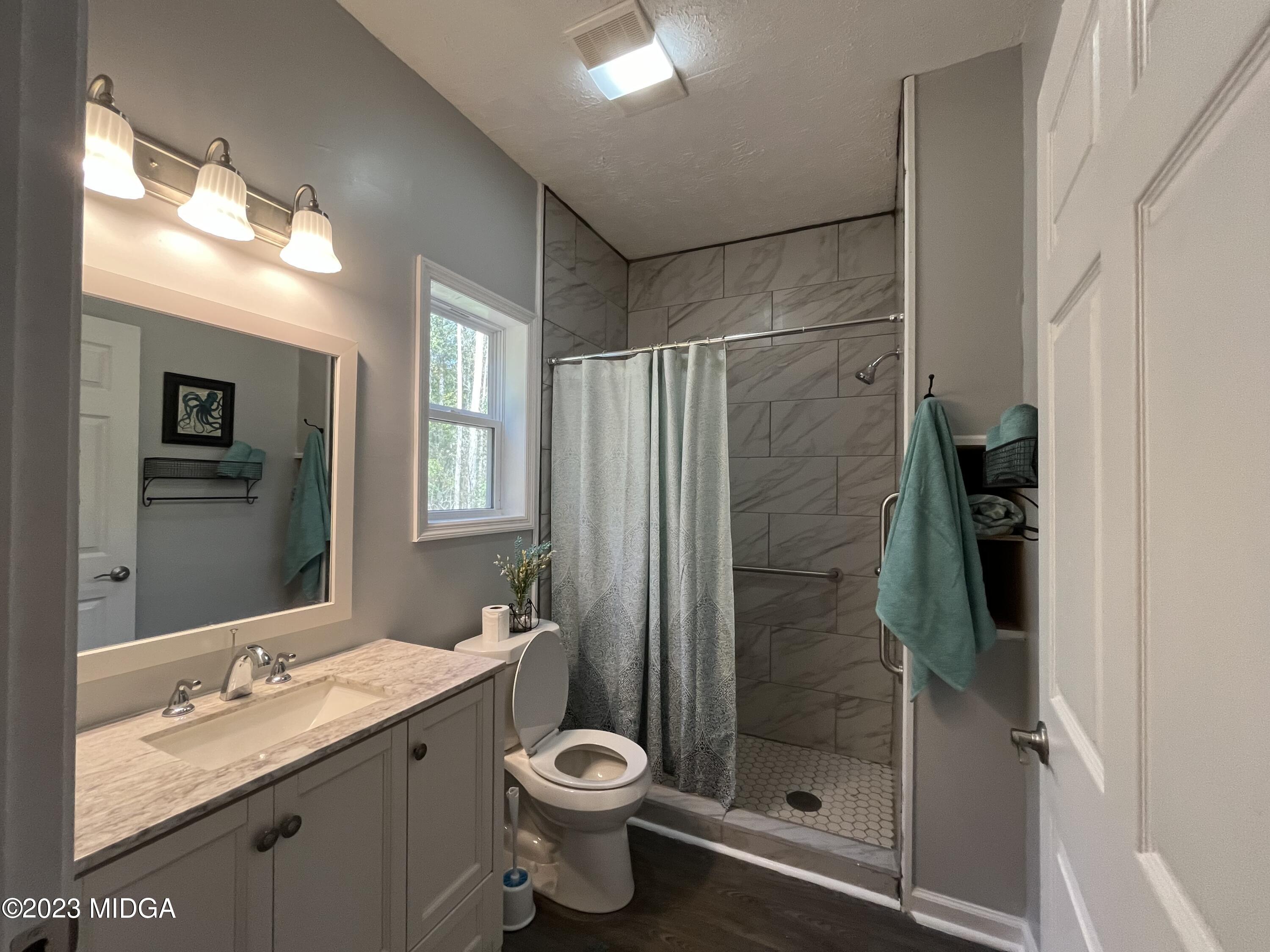 368 Mott Road Barnesville, GA 30204 - Photo 9 of 17 a bathroom with a granite countertop sink toilet and shower