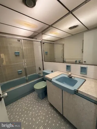 a bathroom with a sink a toilet a mirror and bathtub