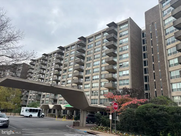 a city view with tall buildings and cars parked on road