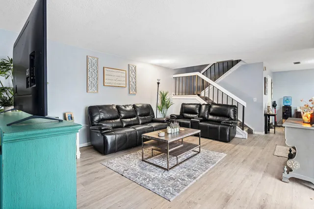 a living room with furniture and a wooden floor
