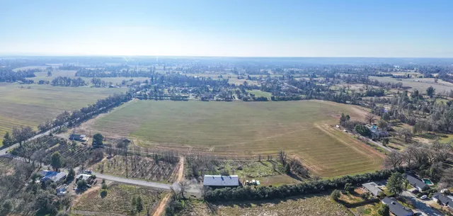 an aerial view of residential houses with outdoor space and trees