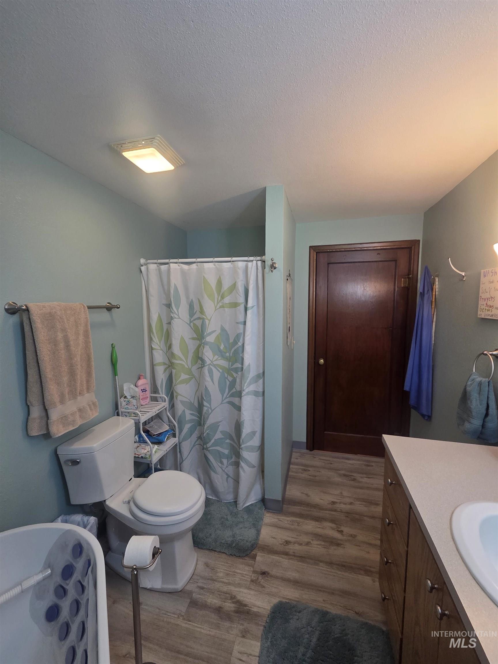 109 South 3rd Street Pomeroy, WA 99347 - Photo 16 of 36 Bathroom featuring wood-finish flooring, a white toilet, and a vanity with a light-colored countertop