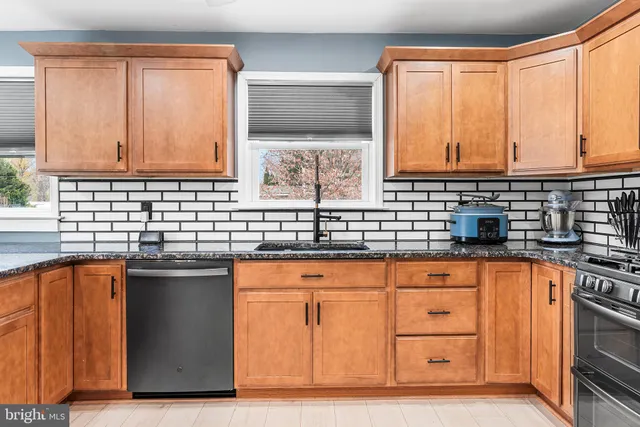a kitchen with stainless steel appliances granite countertop a sink stove and cabinets