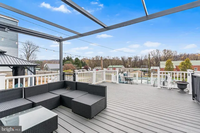 a view of roof deck with seating space and a ocean view