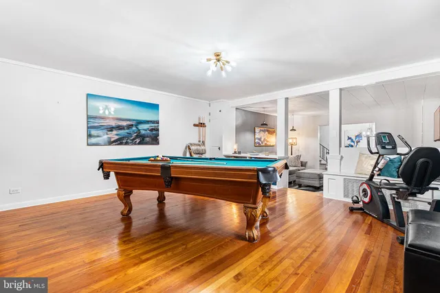 a room with furniture pool table and wooden floor