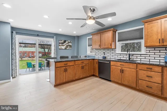 a large kitchen with stainless steel appliances granite countertop a stove sink and cabinets
