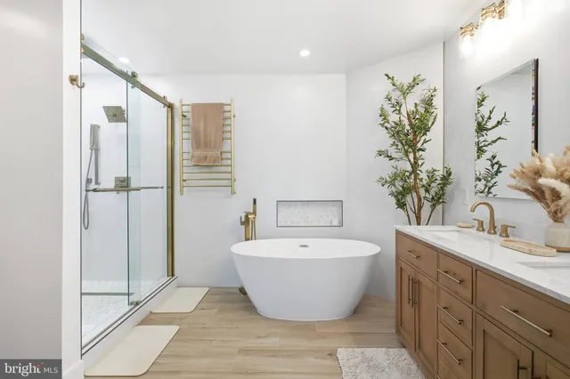 a spacious bathroom with a double vanity sink a large mirror and bathtub