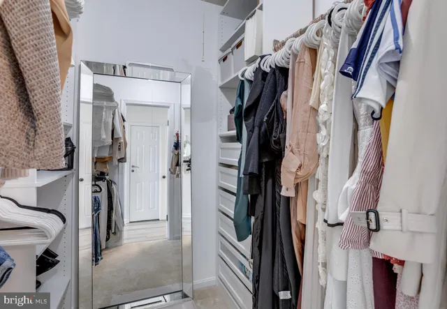 a view of walk in closet with clothes and shoes