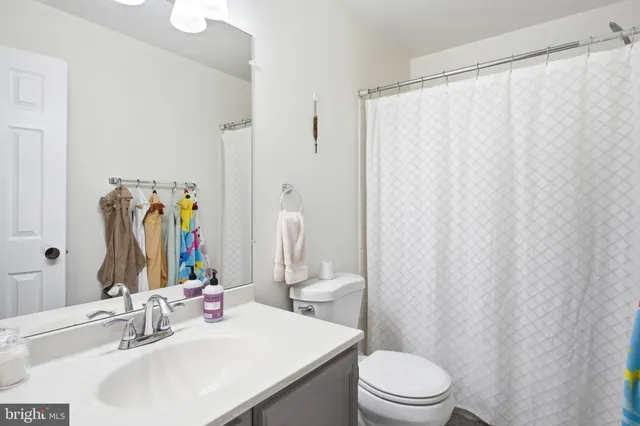 a bathroom with a sink a toilet and shower curtain