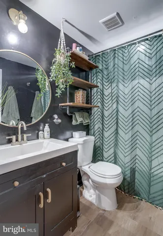 a bathroom with a toilet sink and mirror