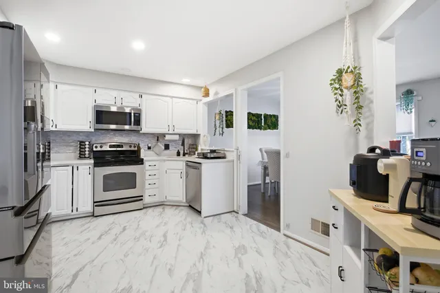 a kitchen with a refrigerator and a stove top oven