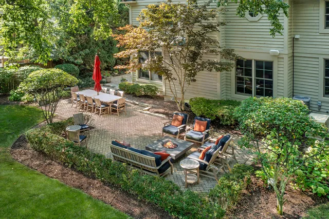 a backyard of a house with table and chairs and potted plants