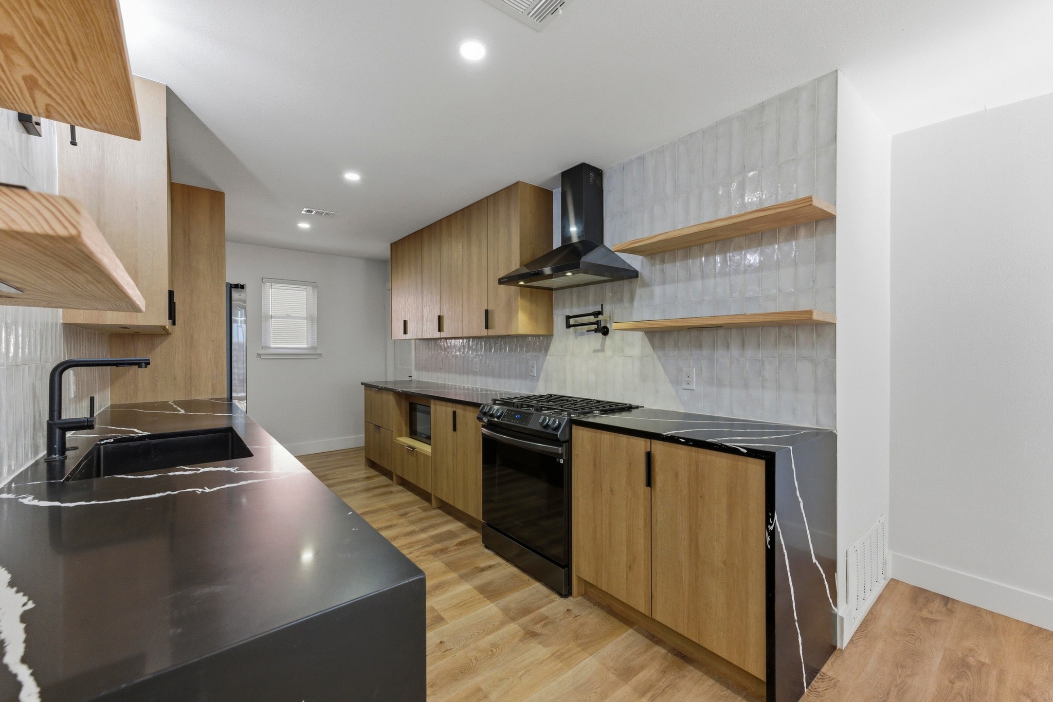 3817 Leafield Drive Austin, TX 78749 - Photo 12 of 31 a kitchen with stainless steel appliances granite countertop a sink stove and refrigerator