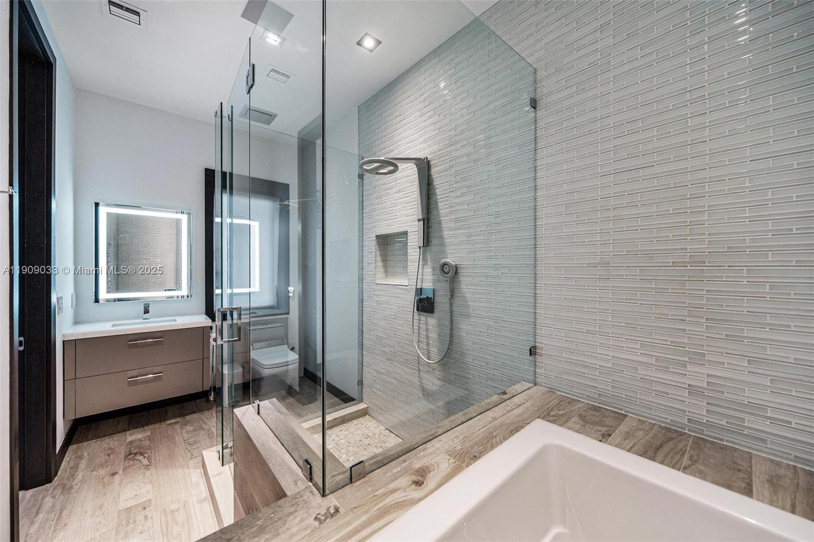 8961 Southwest 62nd Court Pinecrest, FL 33156 - Photo 41 of 72 a bathroom with a tub a sink a mirror and a shower