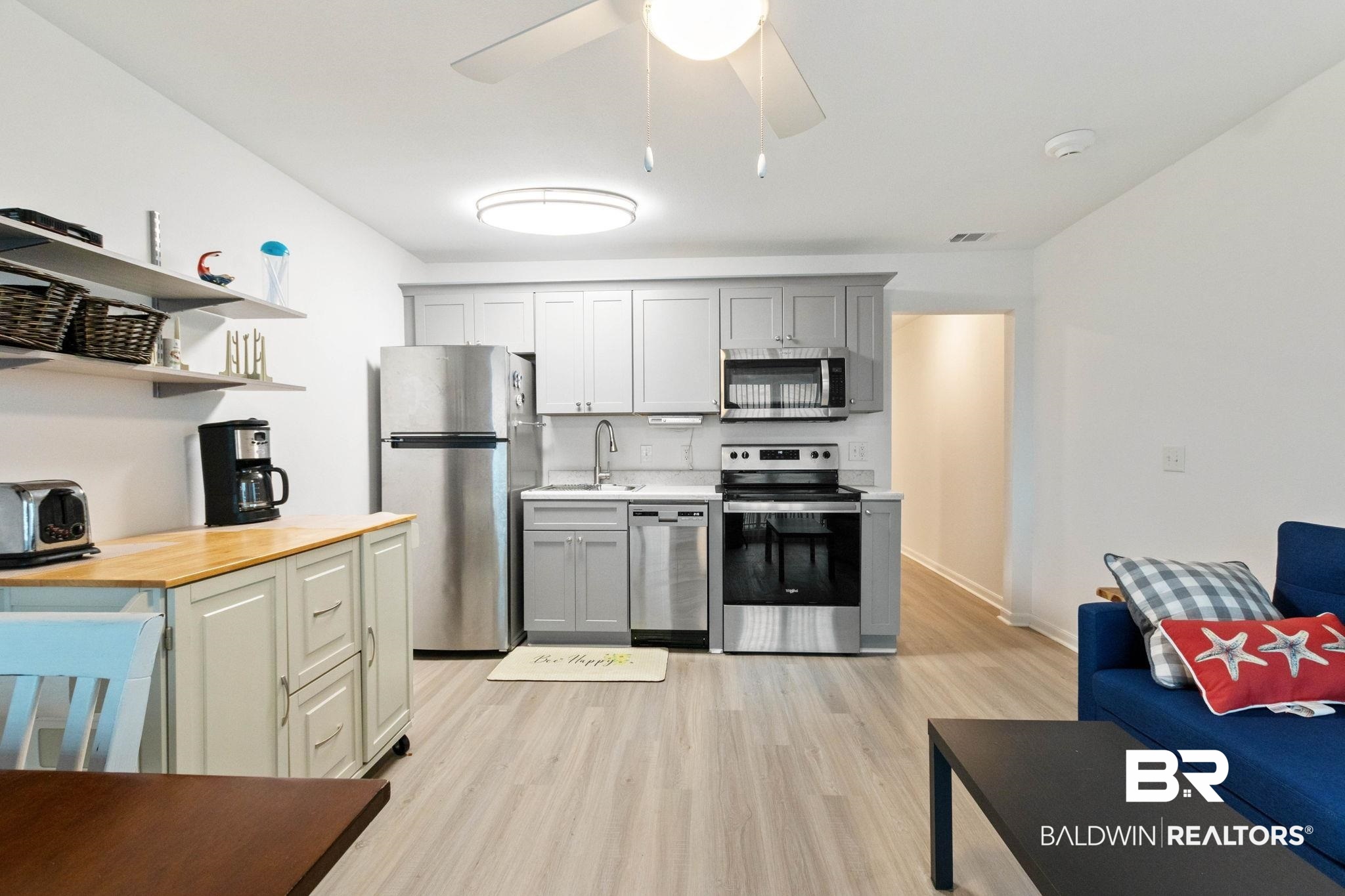 400 Plantation Road, Unit 4501 Gulf Shores, AL 36542 - Photo 10 of 30 Open-concept living area featuring light wood-finish flooring, a kitchen with stainless steel appliances, grey cabinetry, and light countertops