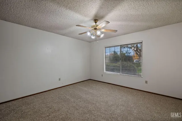 a view of a livingroom with a ceiling fan and refrigerator