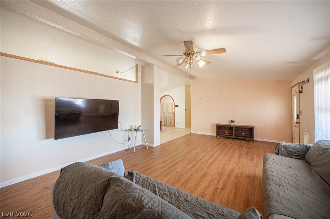 3200 Maple Road Pahrump, NV 89048 - Photo 11 of 53 A spacious common area with warm wood-tone flooring and a ceiling fan offers comfortable living.
