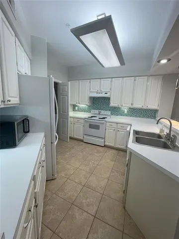 a kitchen with a sink a stove a refrigerator and cabinets