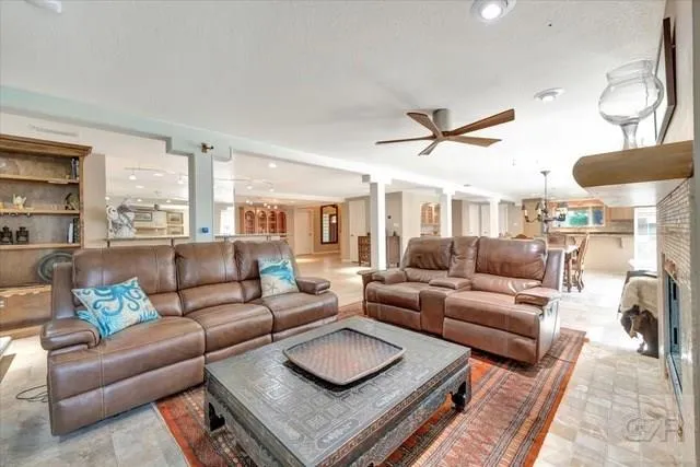 a living room with furniture a ceiling fan and a rug