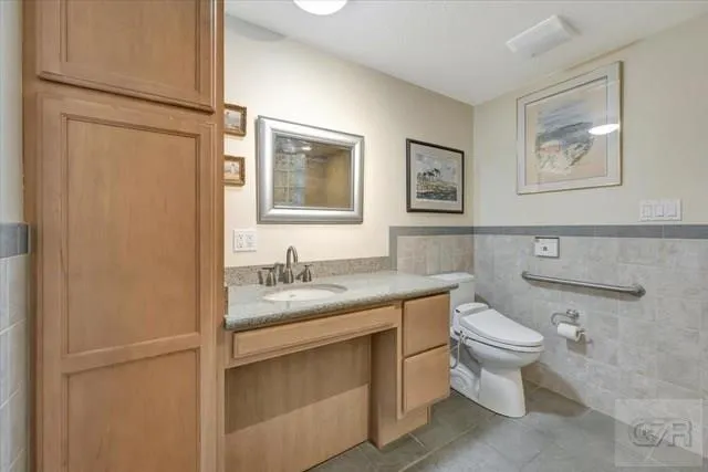 a bathroom with a granite countertop toilet sink and mirror