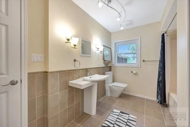 a bathroom with a toilet a sink and mirror