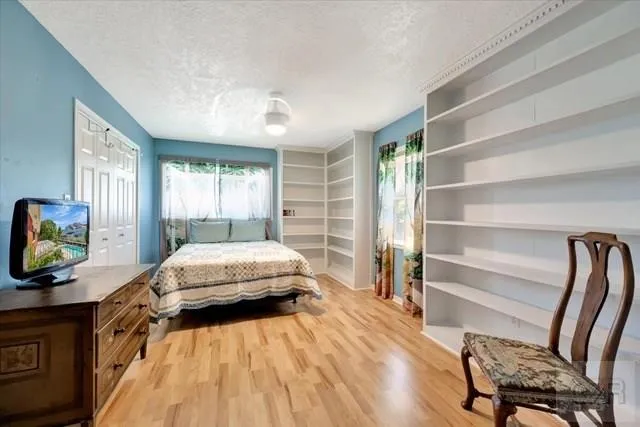 a bedroom with a bed and a flat tv screen on dresser
