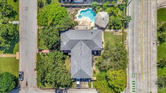 an aerial view of a house with garden space and swimming pool