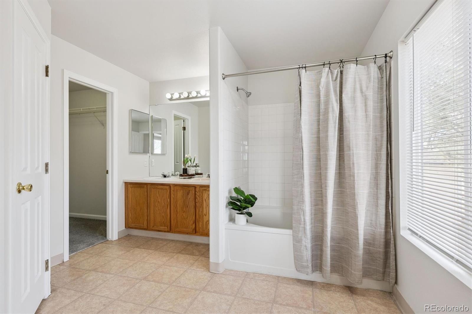 5241 Helena Street Denver, CO 80239 - Photo 13 of 28 a bathroom with a granite countertop sink and a mirror