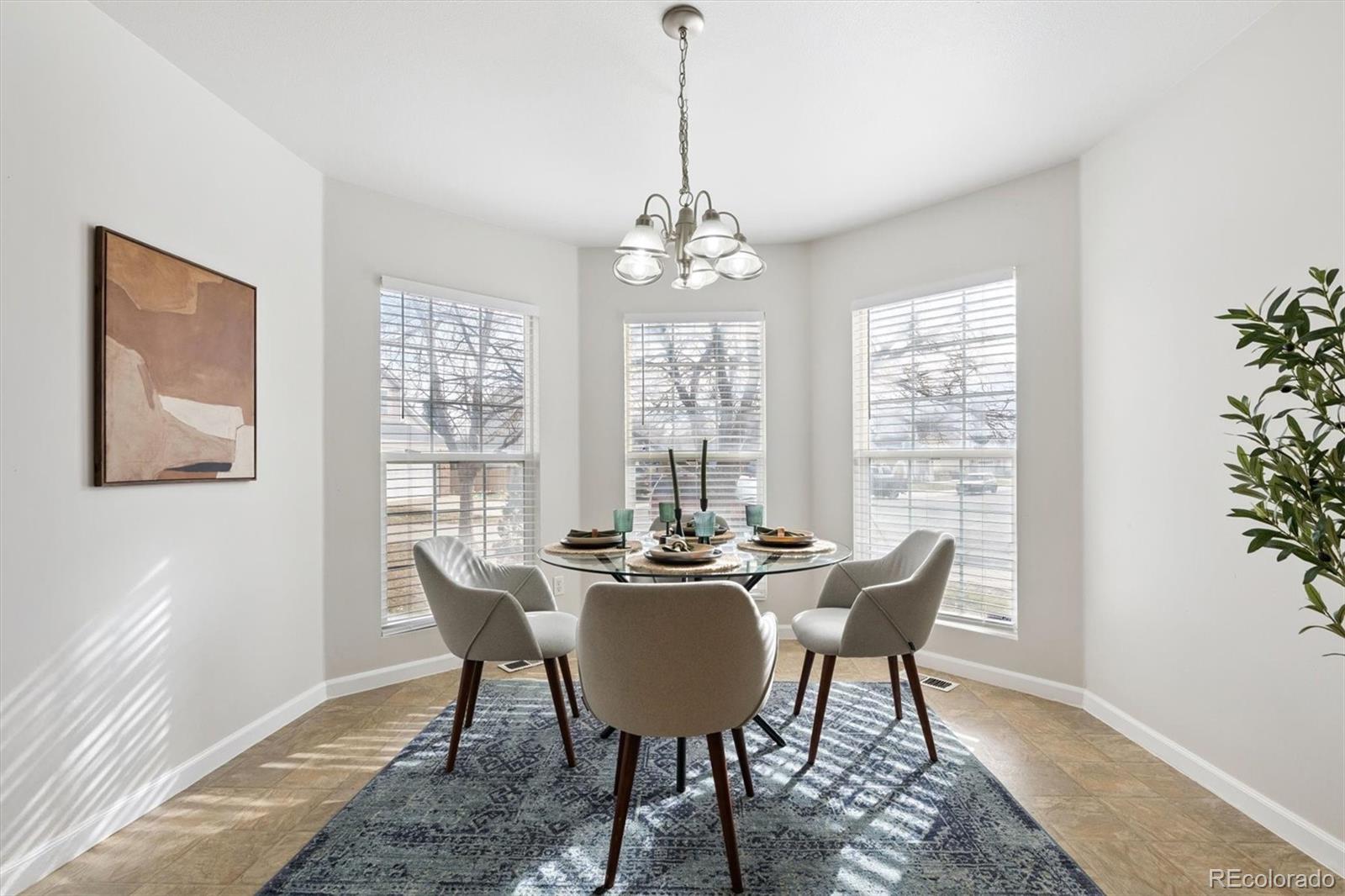 5241 Helena Street Denver, CO 80239 - Photo 10 of 28 a dining room with furniture a chandelier and wooden floor
