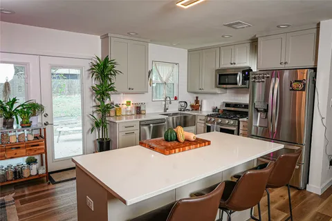 a kitchen with a table chairs refrigerator and microwave