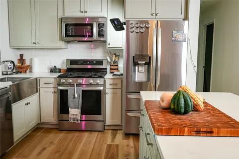 a kitchen with stainless steel appliances granite countertop a refrigerator stove and sink