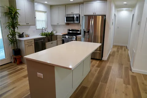 a kitchen with a sink a refrigerator and a stove top oven