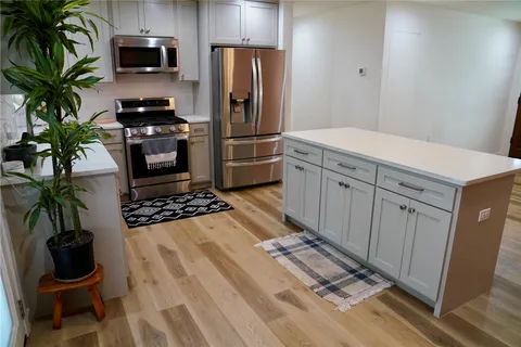 a kitchen with stainless steel appliances a stove a refrigerator and a sink