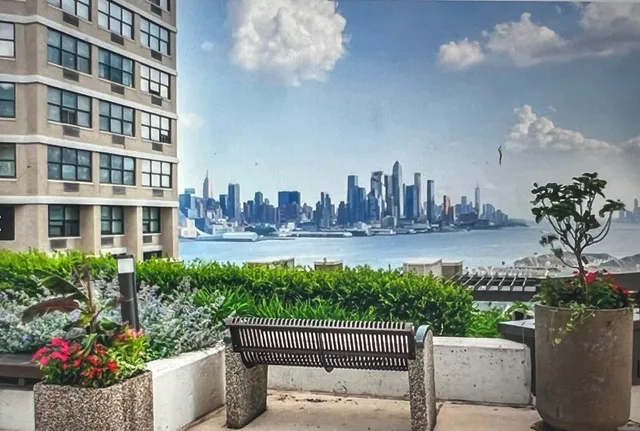 a front view of a building with garden and trees