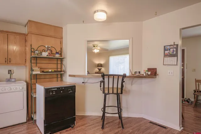 a kitchen with refrigerator cabinets and wooden floor